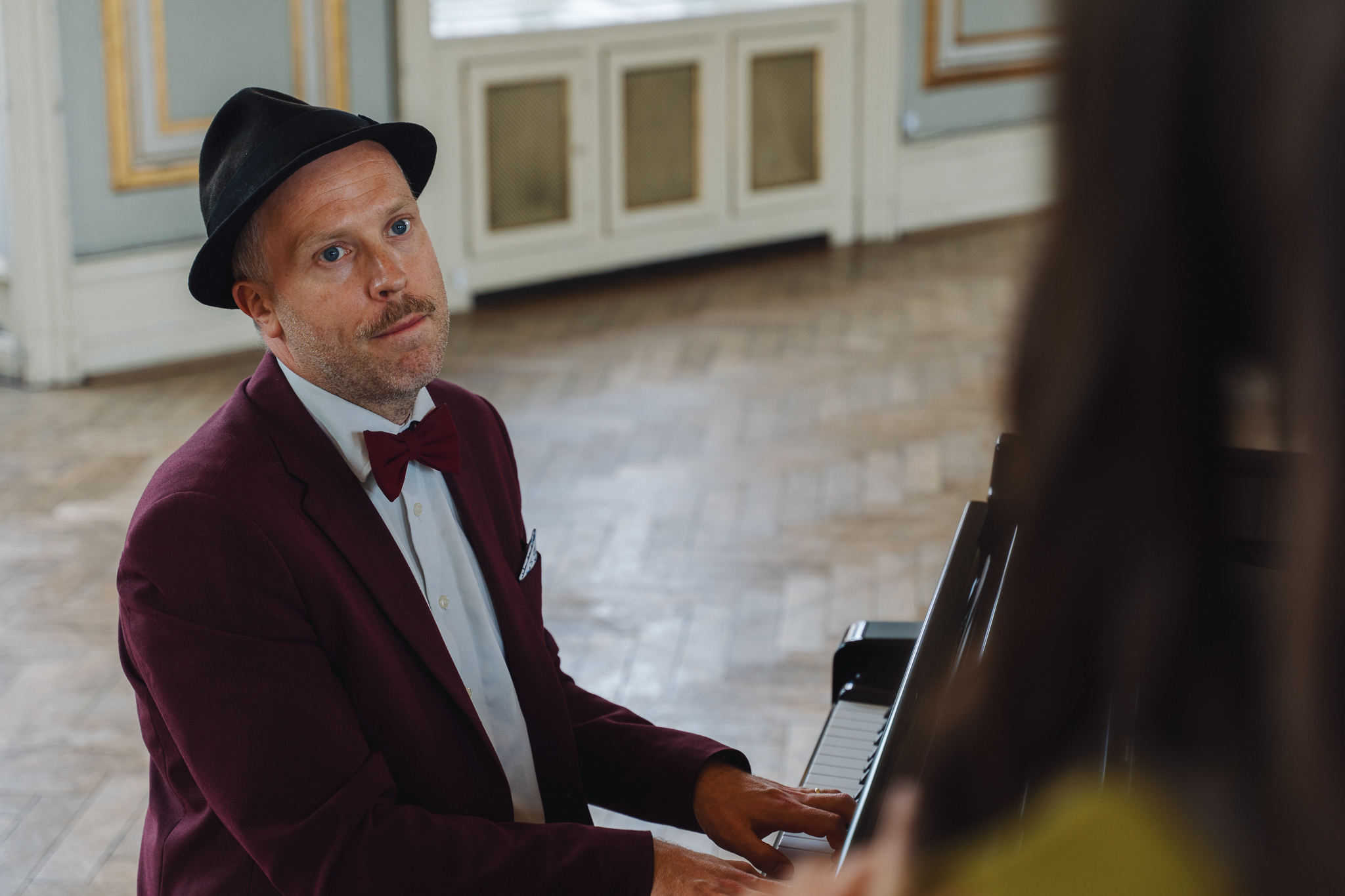 Pianist ved flygel med øjenkontakt mod publikum — tilpasning til gruppen