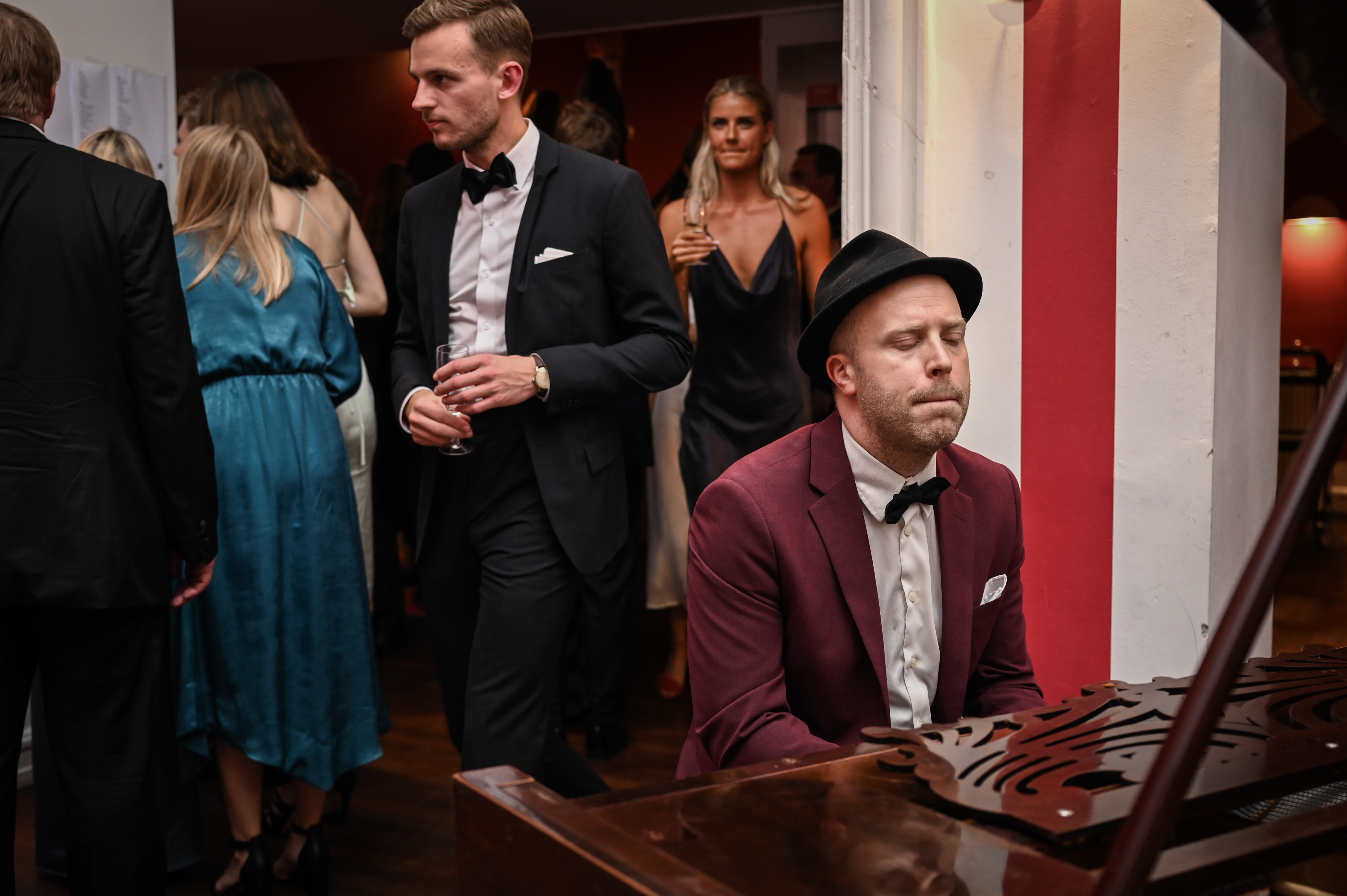 Oscar Gilbert spiller flygel til gallafest i elegant lokale