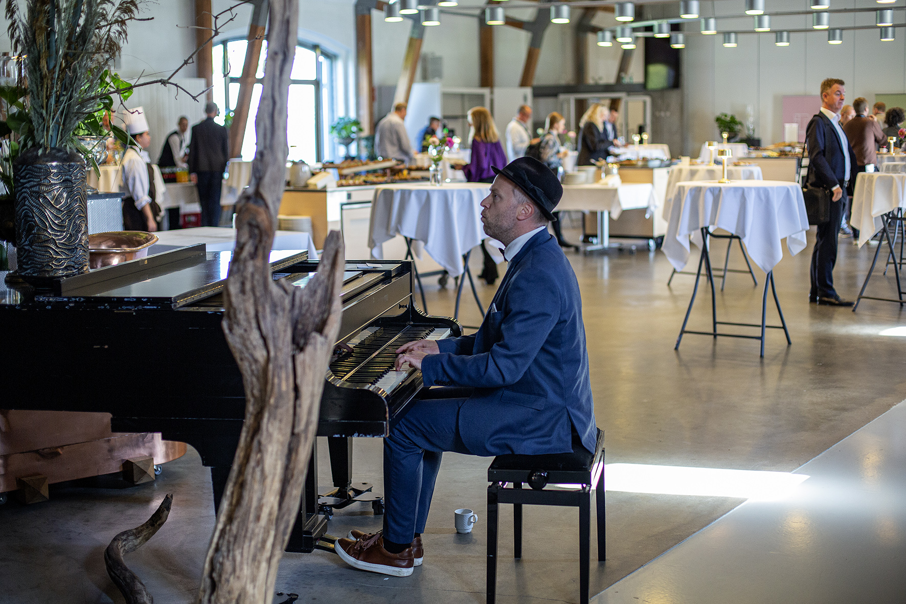 Pianistoptræden ved konference — Oscar Gilbert ved flygel, gæster i selskabslokale
